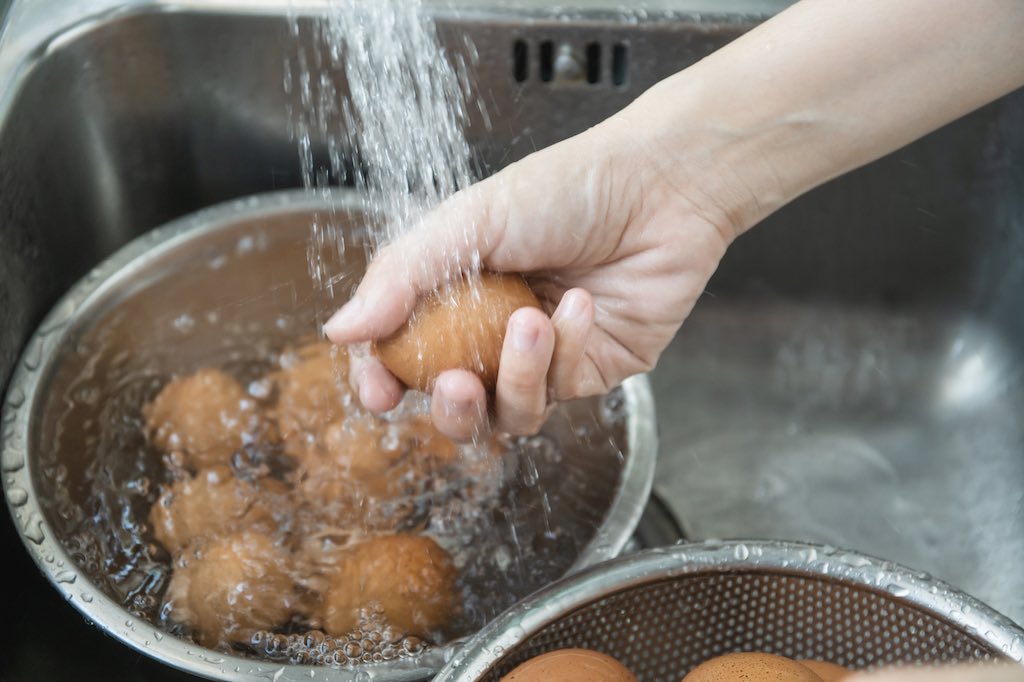 Lavando huevos que tienen suciedad en la cáscara.